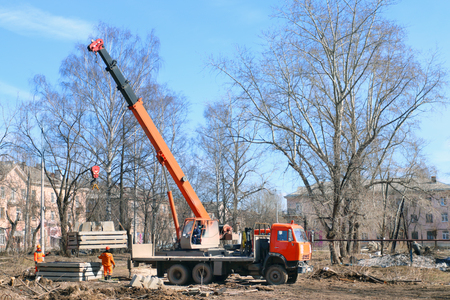 PERM, RUSSIA - APR 14, 2015: Crane unloads truck with concrete slabs  on construction site of largest builder of Perm - Factory of silicate panelsのeditorial素材