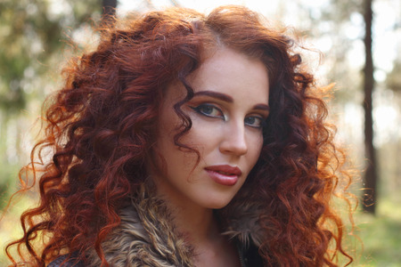 Beautiful girl in black brace poses in sunny autumn forest, close upの写真素材