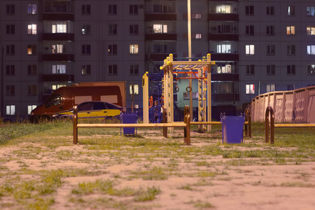 Children playground at night near buildin and cars at summer nightの写真素材