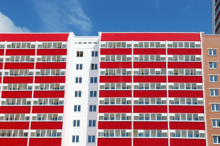 Part of pink residential building with many red loggias at sunny dayの写真素材