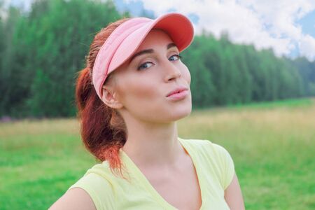 Beautiful slender girl in a yellow shirt stands in the middle of nature and enjoyingの写真素材