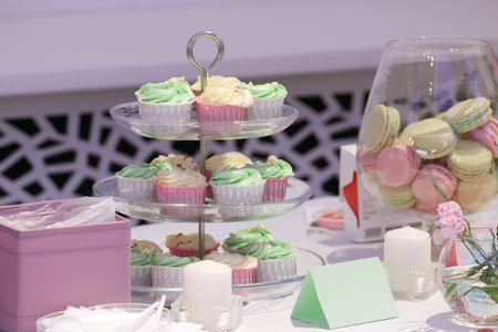 Sweet cupcakes and macarons are on table during celebrationの写真素材