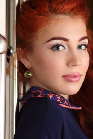 Young woman with beautiful big eyes and professional make-up looks over the shoulderの写真素材