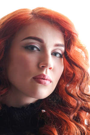 Beautiful young woman with red curly hair and gray big eyes staring forwardの写真素材