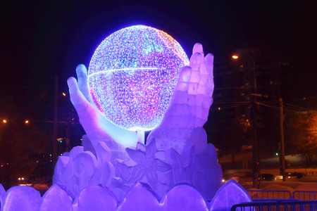PERM, RUSSIA - JAN 10, 2017: Globe in hands with illumination at evening, Ice town of Perm in 2017 Ekosad - largest in Russiaのeditorial素材
