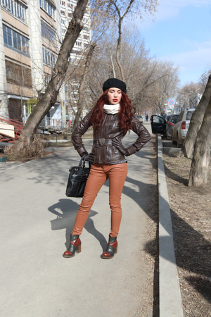 Young woman in leather jacket poses on street at sunny spring dayの写真素材