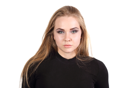 Pretty young blonde girl in black poses isolated on white backgroundの写真素材