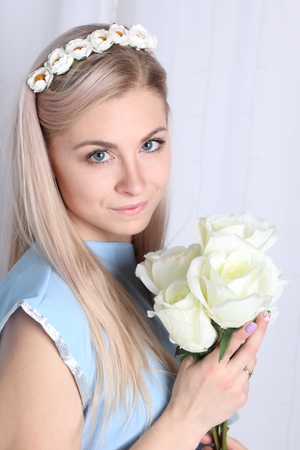 Beautiful young blonde woman with clean skin and flower wreath in her hair on grey background, Keep flowersの写真素材