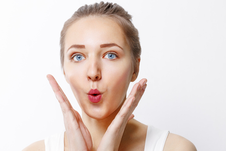 Pretty young girl with make-up is surprised in studio, close up portraitの写真素材