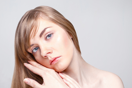 Beautiful caucasian woman with make-up poses in studio, close up portraitの写真素材