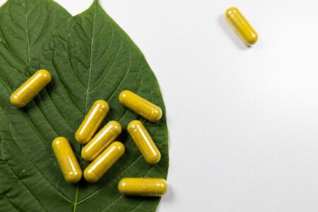 Mitragyna speciosa or kratom leaves with medicinal products on wooden table.の写真素材