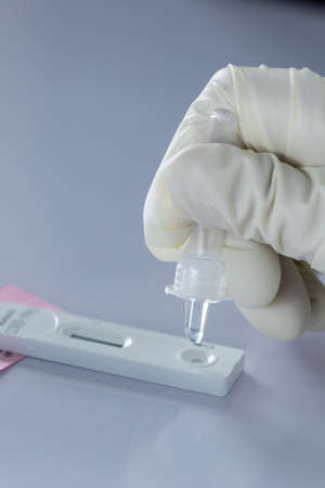 The doctor with PPE suit, Doctor is using a test coronavirus(covid-19) with the use of an ATK test kit by nasal swab.の写真素材