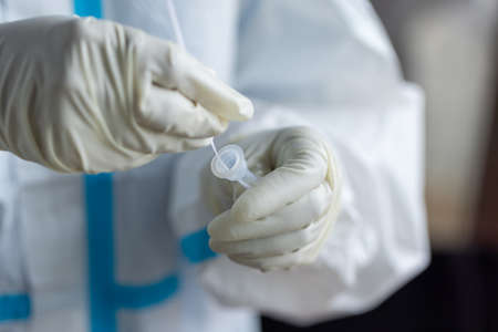The doctor with PPE suit, Doctor is using a test coronavirus(covid-19) with the use of an ATK test...