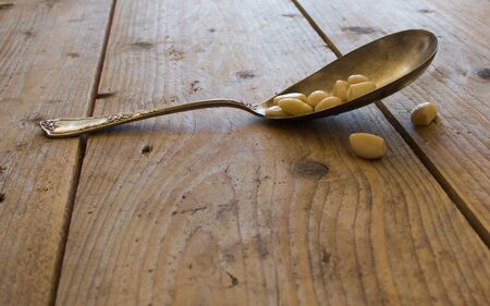 Spoon with pine nut on the tableの写真素材