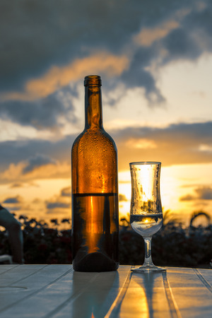 Bottle and glass with muscat on a background of a luxury sunset of tropicheskgo climateの写真素材