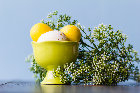 Easter. Three yellow colored eggs in a ceramic bowl.の写真素材