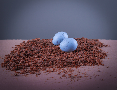 Two easter blue mottled eggs on the texture brown background.