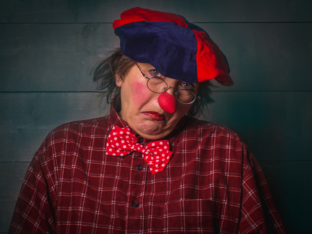 Clown with glasses, in plaid shirt and beret with funny facial expressions.の写真素材