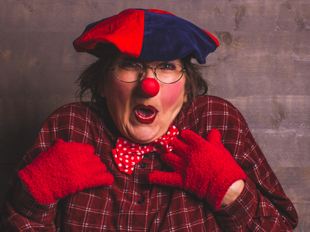 Woman funny clown with red nose and gloves.の写真素材