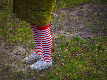 Woman in striped stockings on grass backgroundの写真素材