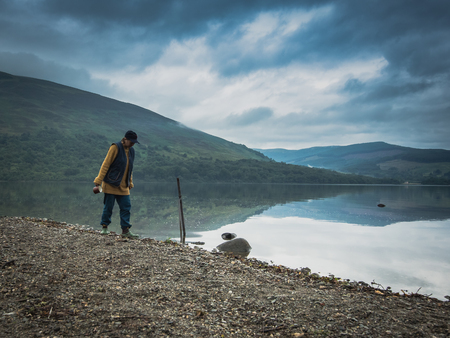 Mature woman in the morning near the lake in warm tourist clothiの写真素材