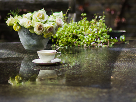 Romantic bouquet of white roses with elegant porcelain cup in the gardenの写真素材