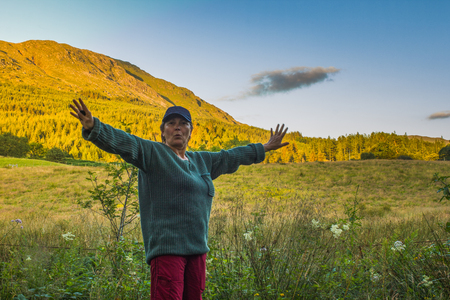 Sporty senior woman raise up hand with joy and happiness in nature.の写真素材