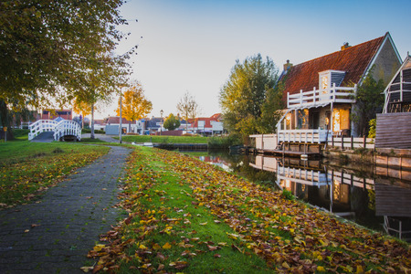 View of the authentic  village, with canal, wooden small footbridge wooden white bridge and houses. Holland, Friesland province.の写真素材
