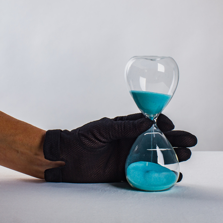 The hand of a woman with sand timer close-up. Age and life of women, concept.