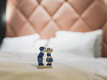 Delftware figure of a boy and a girl kissing in a hotel room, a place in which someone stays temporarily, close-up, blurred background with copy spaceの写真素材