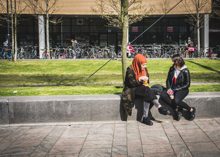 ROTTERDAM - NETHERLANDS -APRIL, 15, 2019: Two girls sits and drinking fresh smoothies in spring city.のeditorial素材