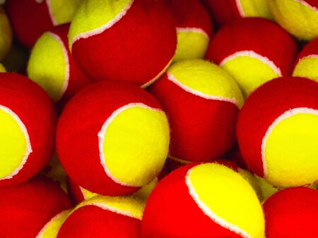 group of yellow and red tennis balls in the sports shopの写真素材