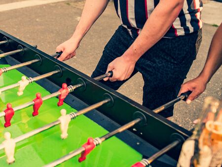 People playing table football outdoor, summer holiday.