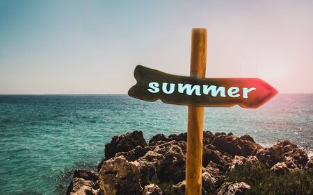 Pillar with a pointer to the beach and the text summer on the background of the sea,の写真素材