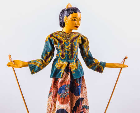 Indonesian woman traditional puppet in folklore clothes on a white background, copy space for your object or text.の写真素材