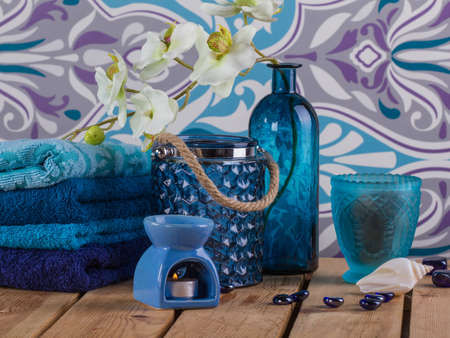 Spa objects: set towels in blue colors, colored glass, shell and candles.の写真素材
