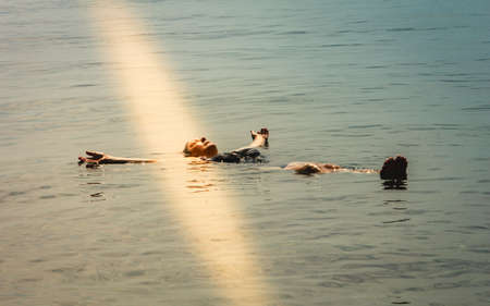An elderly woman relaxes, allowing herself to dodge in seawater. Beautiful healthy life in nature.の写真素材