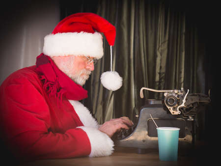 Santa Claus writing a letter with old typewriter.の写真素材