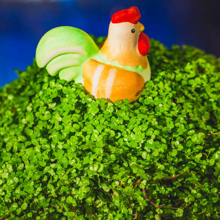 Simple Easter decoration ceramic rooster in pattern of green leaf.