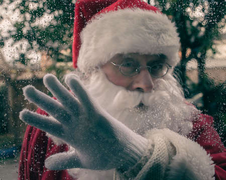 Santa Claus wipes wet windows.の写真素材