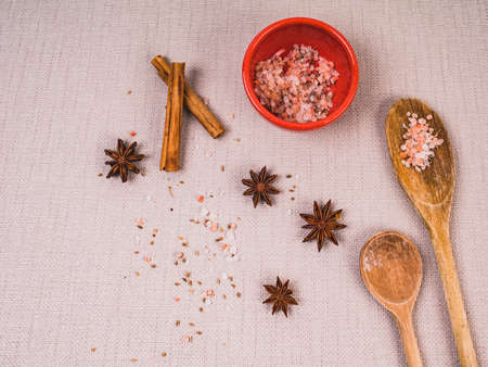 Used wooden spoons, ceramic orange pot and spices on natural textile background, top view, kitchen splash, country style.の写真素材