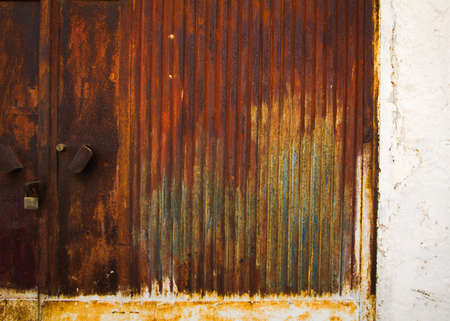 Rusty metal garage door background. Old oxidized colorful textured surface.の写真素材