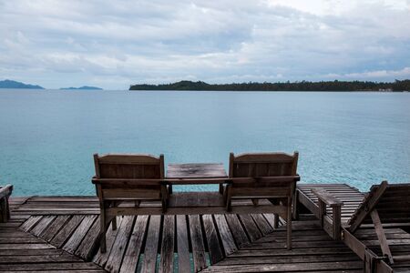 Balcony overlooking the lake with outdoor wooden chairs and tables