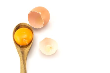 egg raw split yolk on the wood spoon