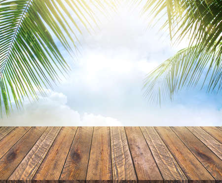Empty wooden table and palm leaves background in the daytime.