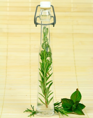 Bottle with fresh herbs for medicine or cookingの写真素材