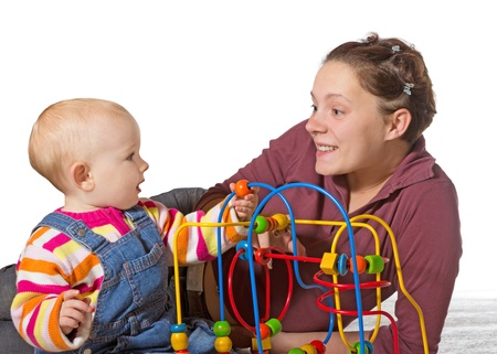 Baby with motor activity development delay being stimulated to develop coordination and muscle control and movement on a bead maze by an adoring mother Baby with motor activity development delay being stimulated to develop coordination and muscle control and movement on a bead maze by an adoring mother