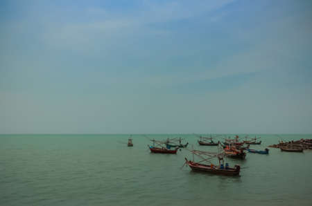 fishery boats floating near the coast with beautiful blue skyの写真素材
