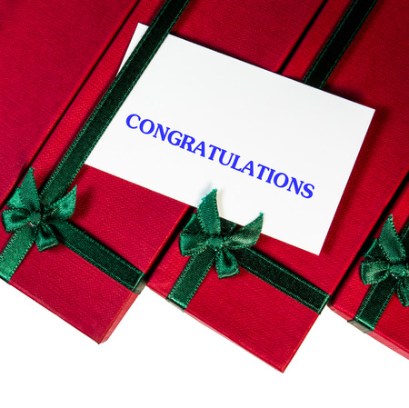 red gift box with ribbon and congratulations card on white background