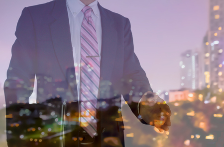 businessman and notebook offer shakehand with blur city night lightの写真素材